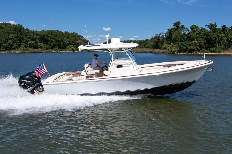 Slide: The Image of 2019 Hunt Yachts 32CC cruising on a lake with lush green shoreline. - 35