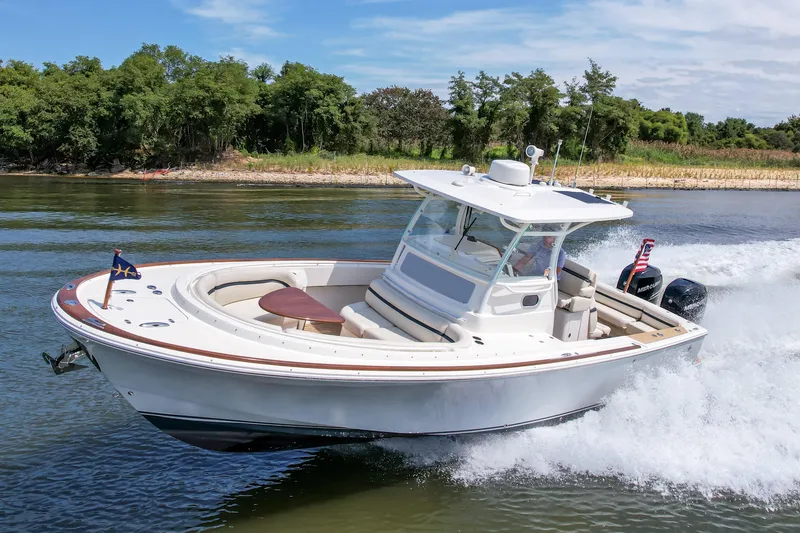 Slide: The Image of 2019 Hunt Yachts 32CC cruising on a scenic waterway with lush greenery. - 38