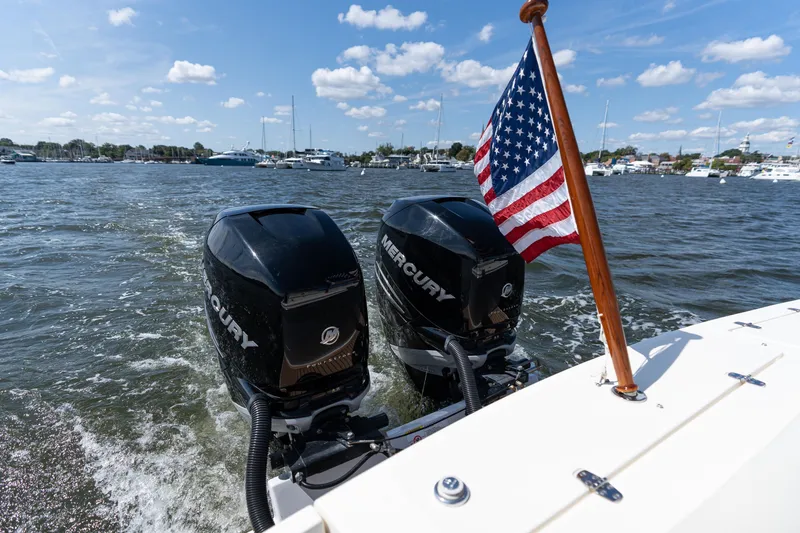 Slide: The Image of 2019 Hunt Yachts 32CC with dual Mercury engines and American flag on open water. - 4