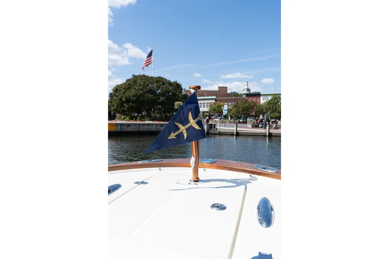 Slide: The Image of 2019 Hunt Yachts 32CC boat with flag, docked near waterfront, American flag in background. - 43