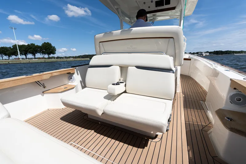 Slide: The Image of 2019 Hunt Yachts 32CC boat interior with luxurious seating and teak flooring on a sunny day. - 8