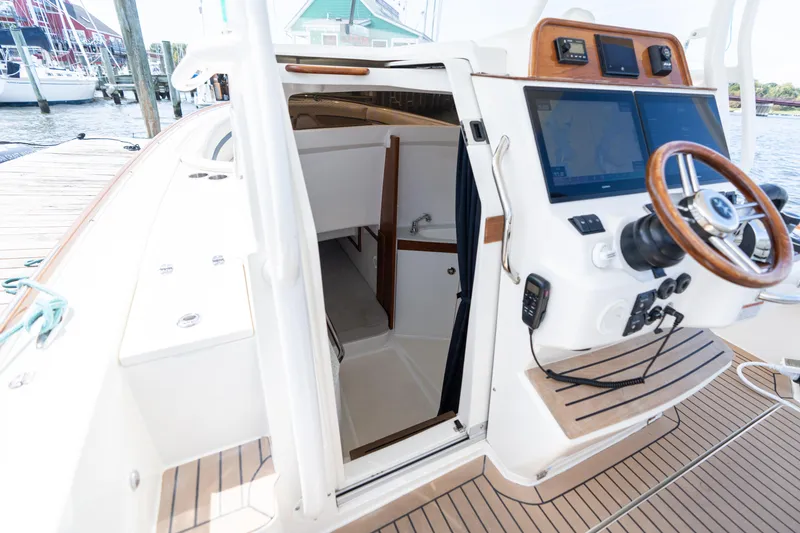 Slide: The Image of 2019 Hunt Yachts 32CC boat interior with helm, navigation screens, and cabin entrance. - 21