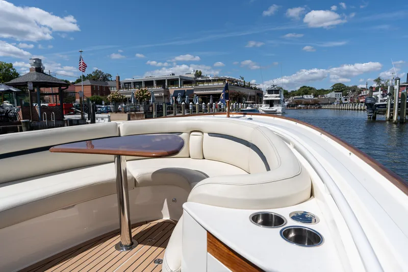 Slide: The Image of 2019 Hunt Yachts 32CC with elegant seating and table, docked at a scenic marina. - 31
