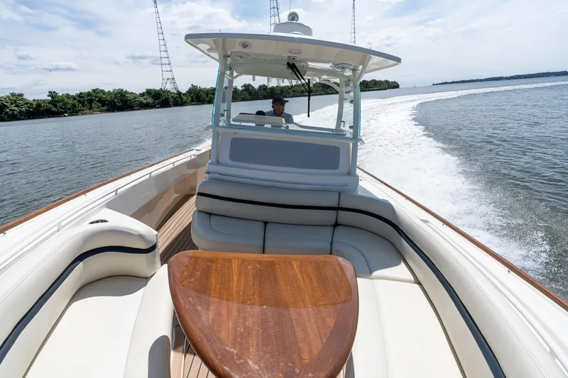 Slide: The Image of 2019 Hunt Yachts 32CC cruising on a scenic waterway, featuring elegant seating and a wooden table. - 33