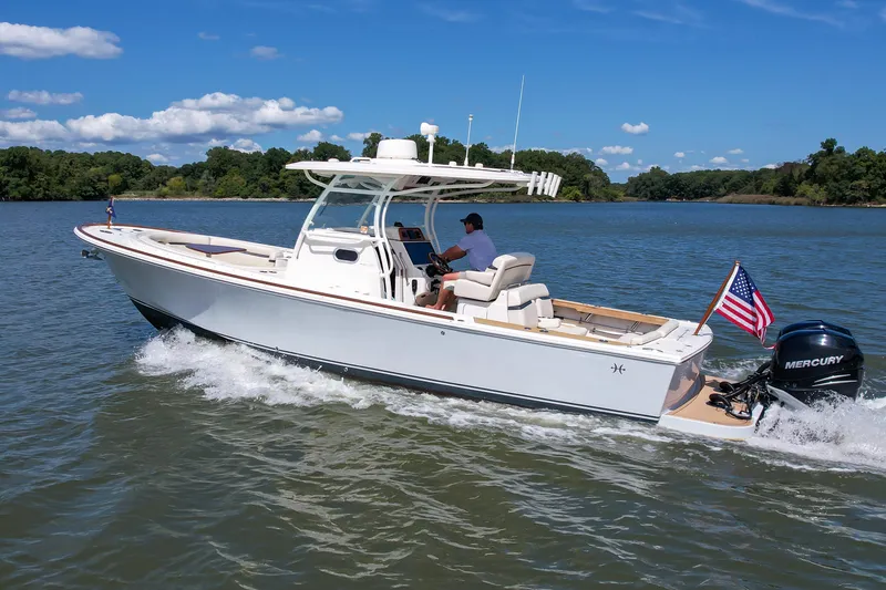Slide: The Image of 2019 Hunt Yachts 32CC cruising on a scenic lake with American flag. - 34