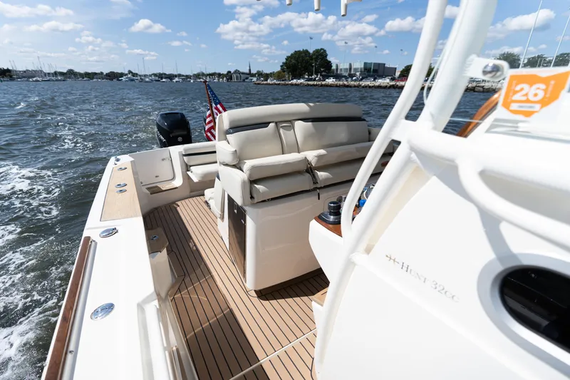Slide: The Image of 2019 Hunt Yachts 32CC on water, showcasing deck and seating, under sunny skies. - 7