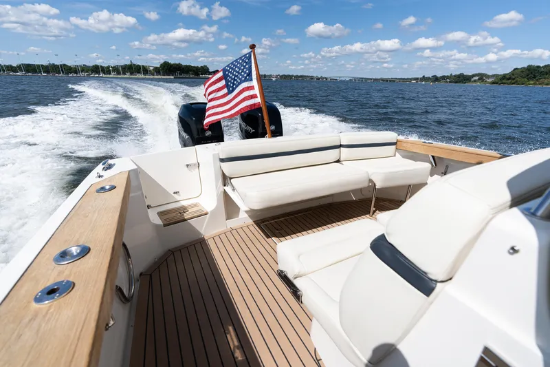 Slide: The Image of 2019 Hunt Yachts 32CC cruising on water, American flag, sunny day, spacious deck. - 9