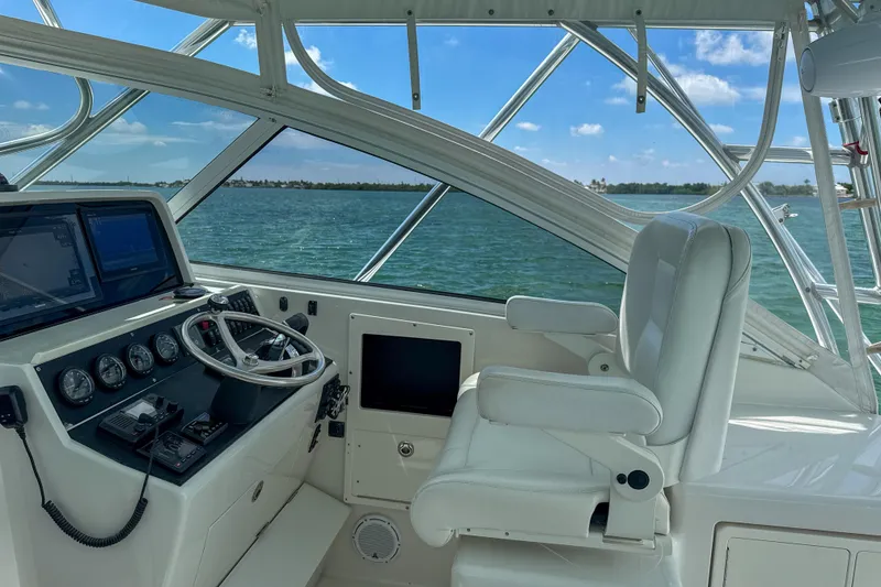Slide: The Image of 2009 Jupiter 39 Express helm with ocean view, featuring navigation controls and captain's chair. - 15