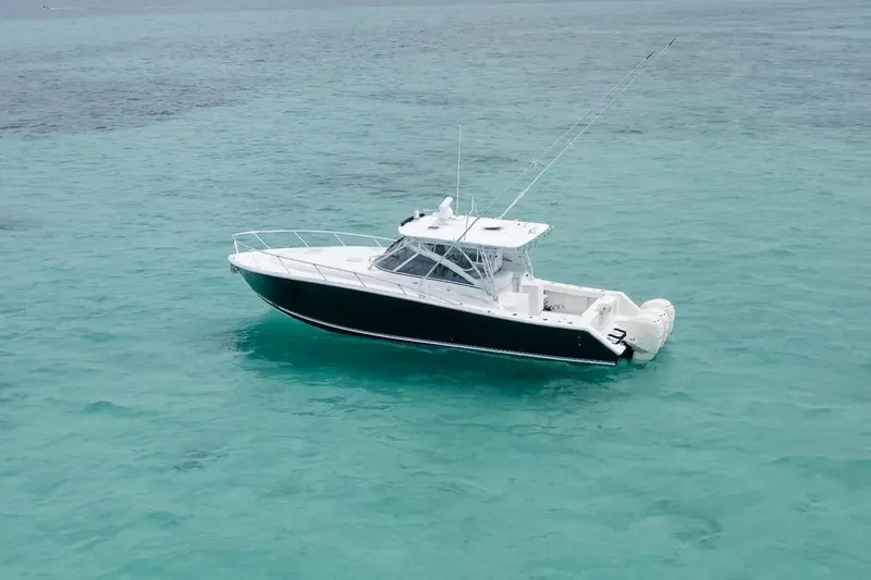 Slide: The Image of 2009 Jupiter 39 Express boat on clear turquoise water under a cloudy sky. - 2
