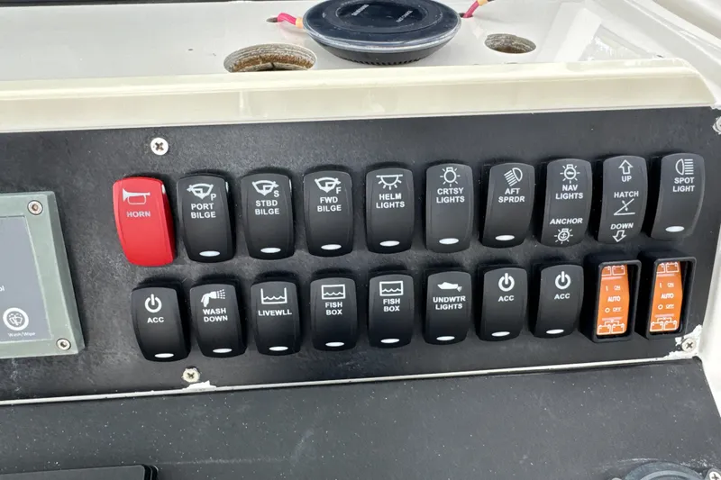 Slide: The Image of Control panel of a 2009 Jupiter 39 Express boat with various switches and indicators. - 28
