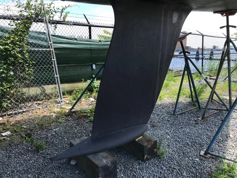 Slide: The Image of Keel of a 1993 Beneteau First 310 sailboat on a gravel yard. - 10