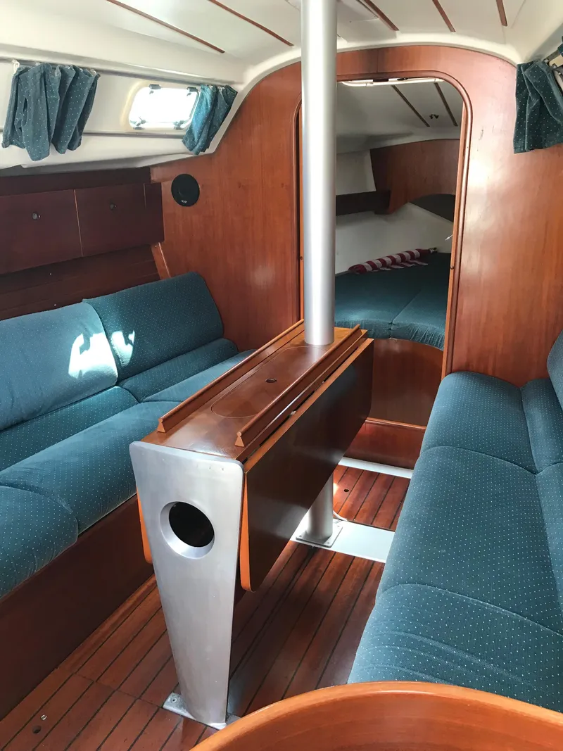 Slide: The Image of Interior of 1993 Beneteau First 310 sailboat with blue seating and wooden finishes. - 28