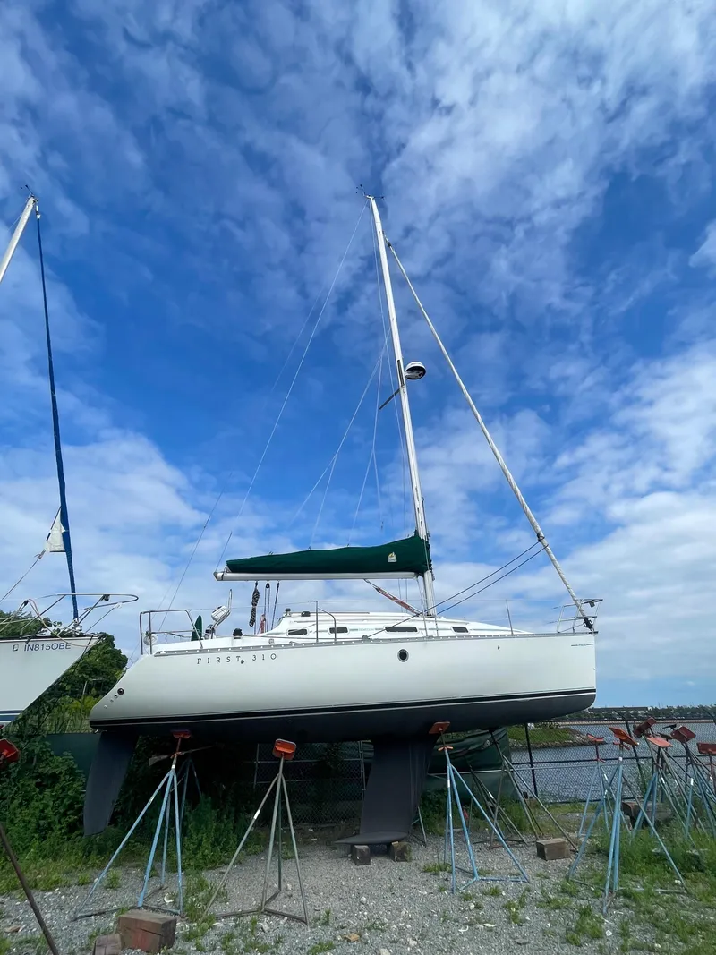 Slide: The Image of 1993 Beneteau First 310 sailboat on stands under a blue sky. - 3