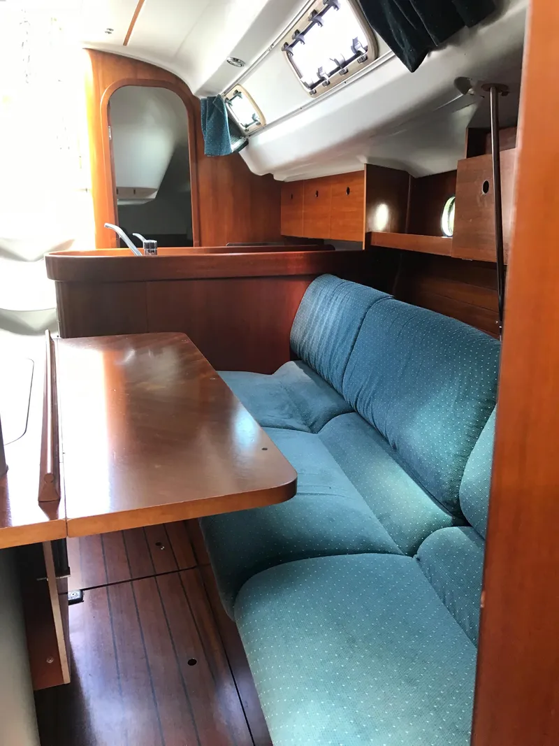 Slide: The Image of Interior of 1993 Beneteau First 310 sailboat with wooden table and blue seating. - 30