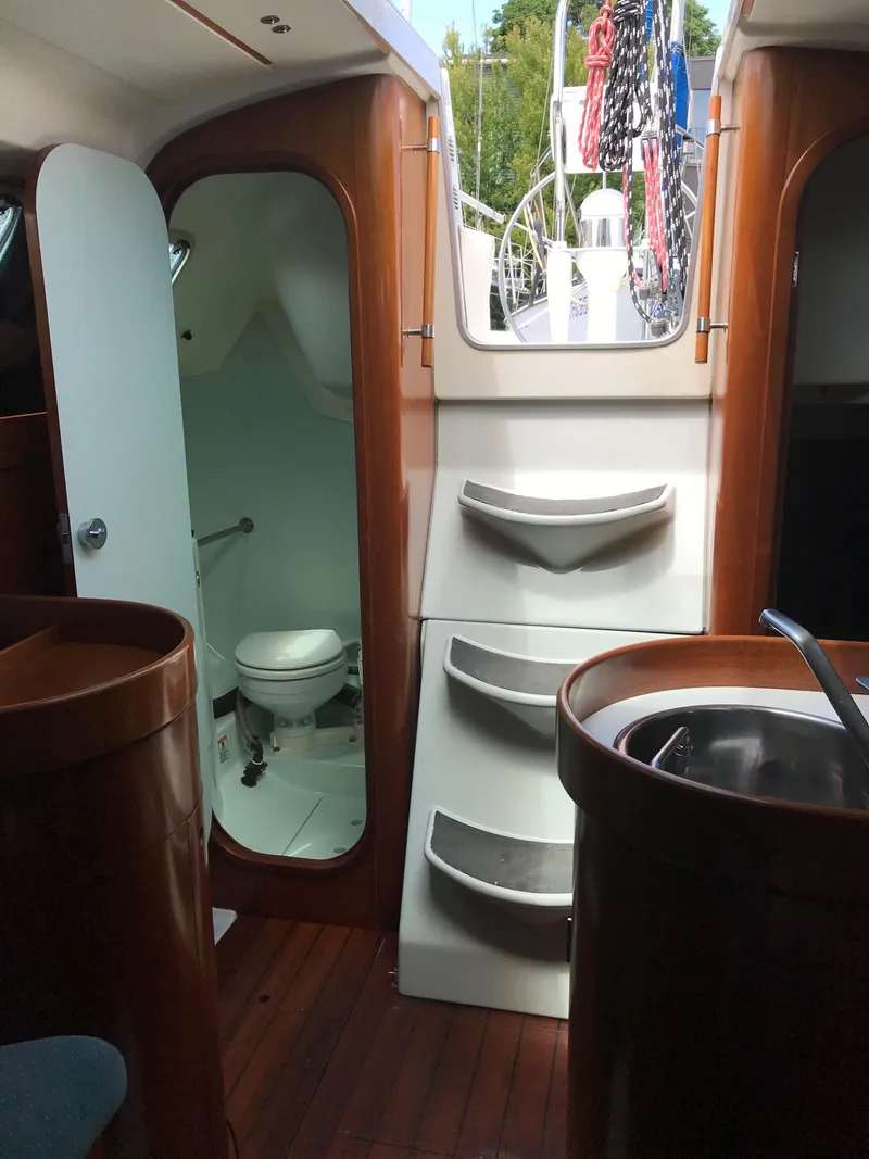 Slide: The Image of Interior of 1993 Beneteau First 310 sailboat with wooden finish and compact bathroom. - 36
