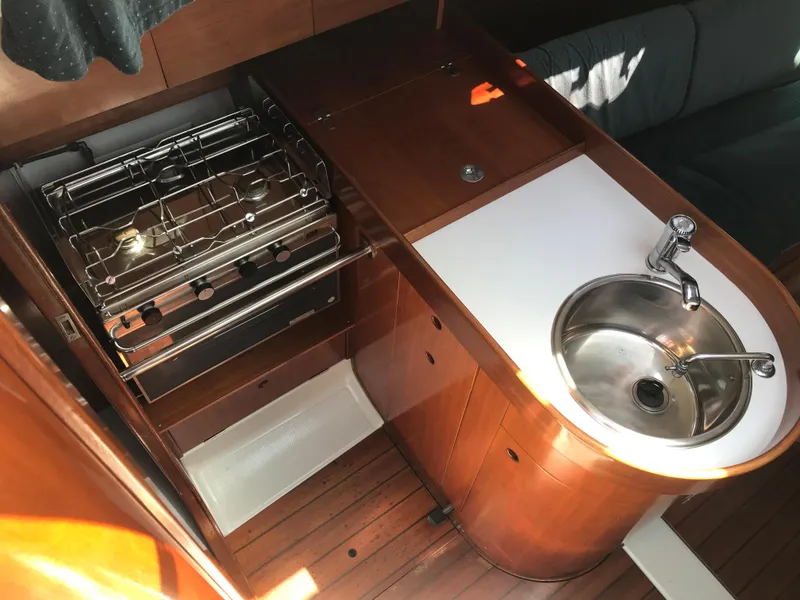 Slide: The Image of 1993 Beneteau First 310 yacht kitchen with stove, sink, and wooden cabinetry. - 41