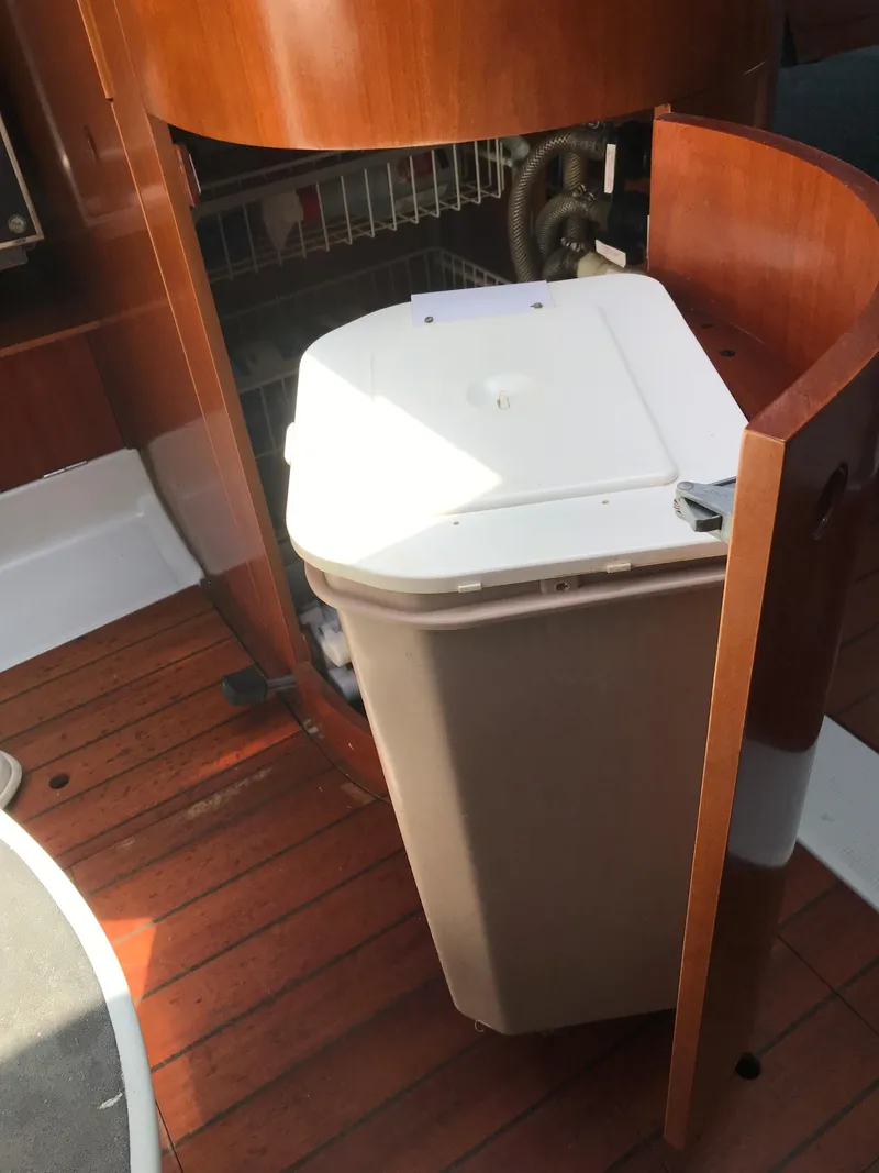 Slide: The Image of Interior of 1993 Beneteau First 310 sailboat with wooden flooring and storage compartment. - 44