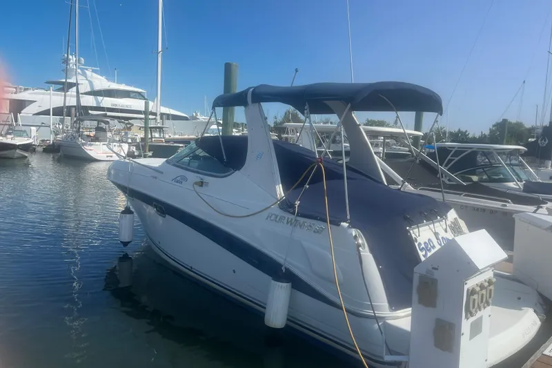 The Image of 2004 Four Winns 268 Vista boat docked in a marina under clear blue skies. - 0
