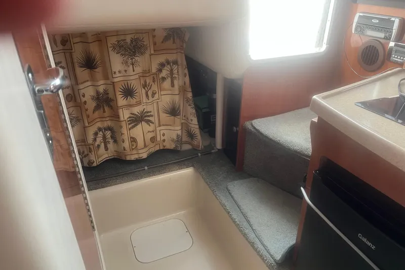 Slide: The Image of Interior of 2004 Four Winns 268 Vista boat with kitchenette and tropical curtain. - 13
