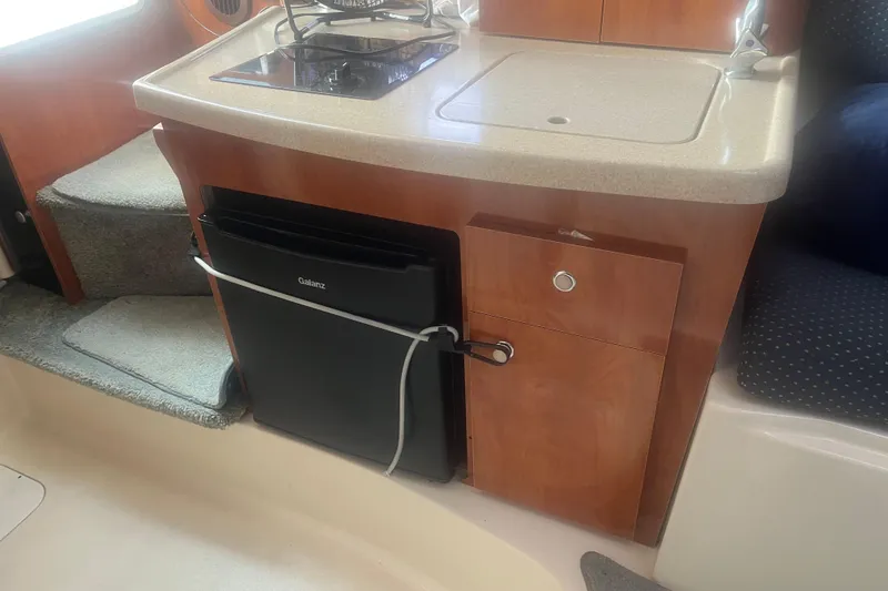 Slide: The Image of 2004 Four Winns 268 Vista boat interior with kitchenette and compact fridge. - 16