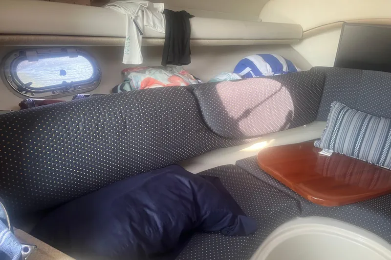 Slide: The Image of Cozy interior of 2004 Four Winns 268 Vista boat with cushions and porthole. - 18