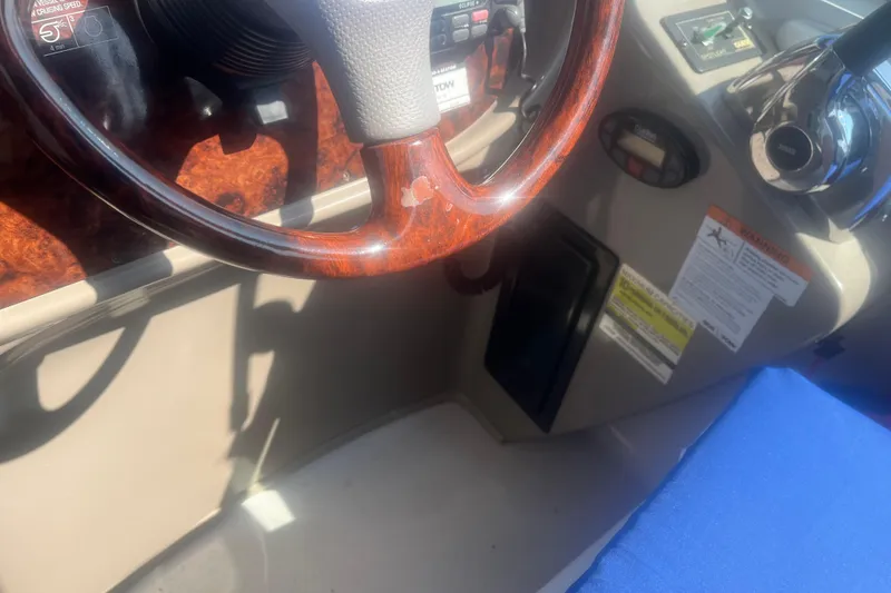 Slide: The Image of 2004 Four Winns 268 Vista boat dashboard with wood steering wheel and controls. - 23