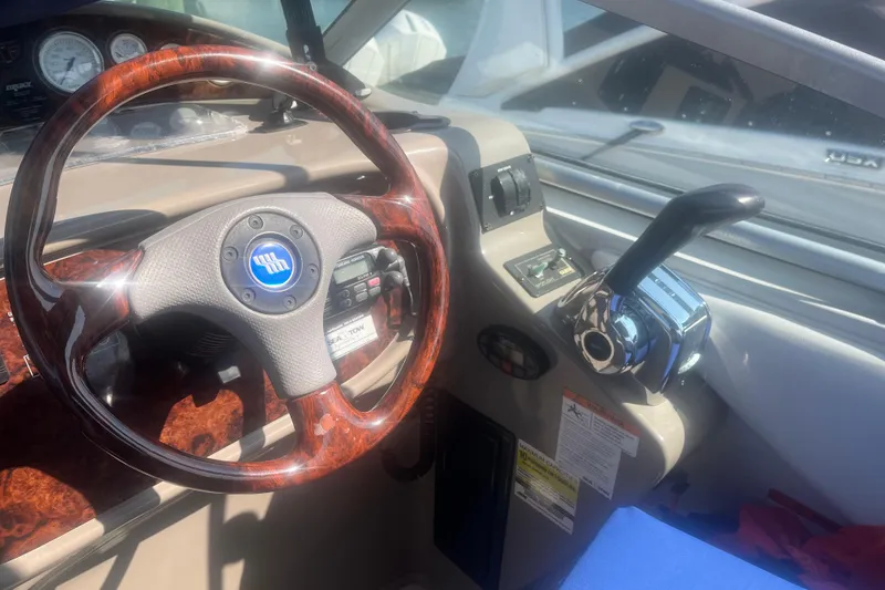 Slide: The Image of 2004 Four Winns 268 Vista boat cockpit with wood-grain steering wheel and control panel. - 26