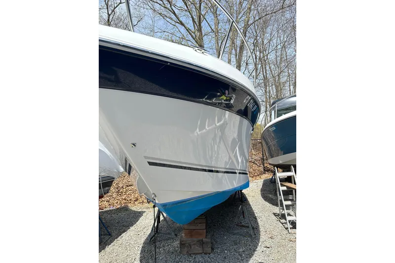 Slide: The Image of 2004 Four Winns 268 Vista boat on dry dock, surrounded by trees. - 27