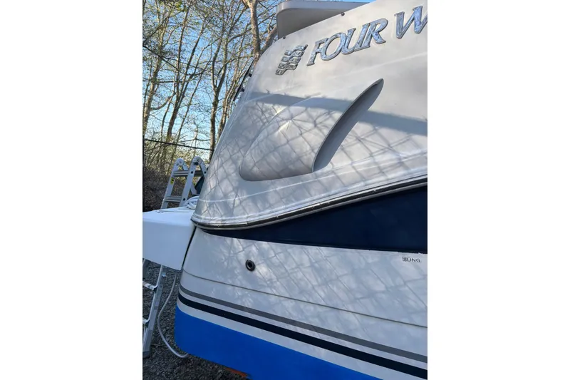 Slide: The Image of 2004 Four Winns 268 Vista boat, side view with branding, outdoors. - 33