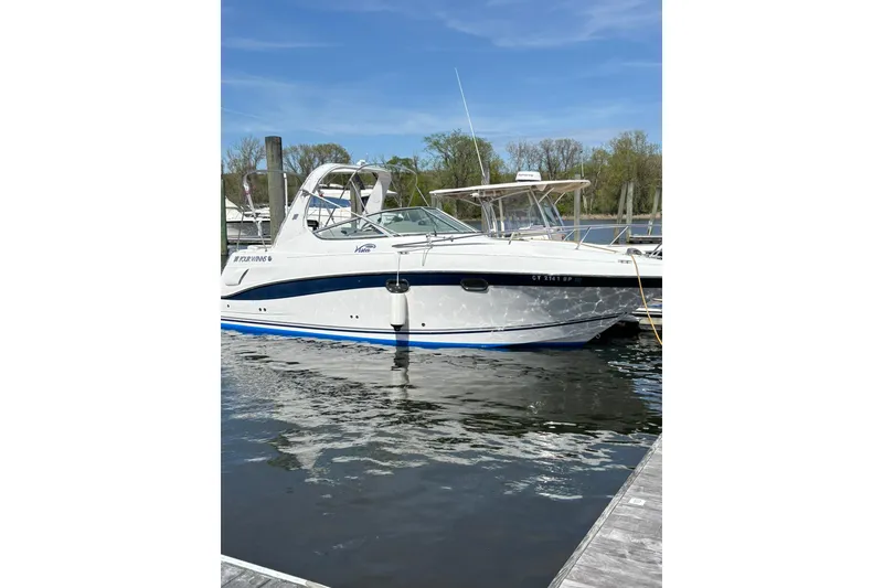 Slide: The Image of 2004 Four Winns 268 Vista boat docked on calm water under clear sky. - 35