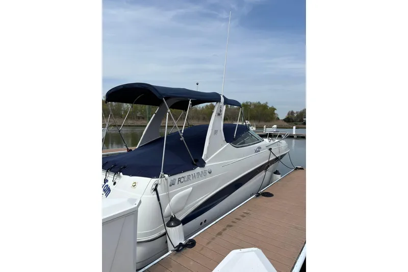 Slide: The Image of 2004 Four Winns 268 Vista boat docked with blue canopy and sleek design. - 37