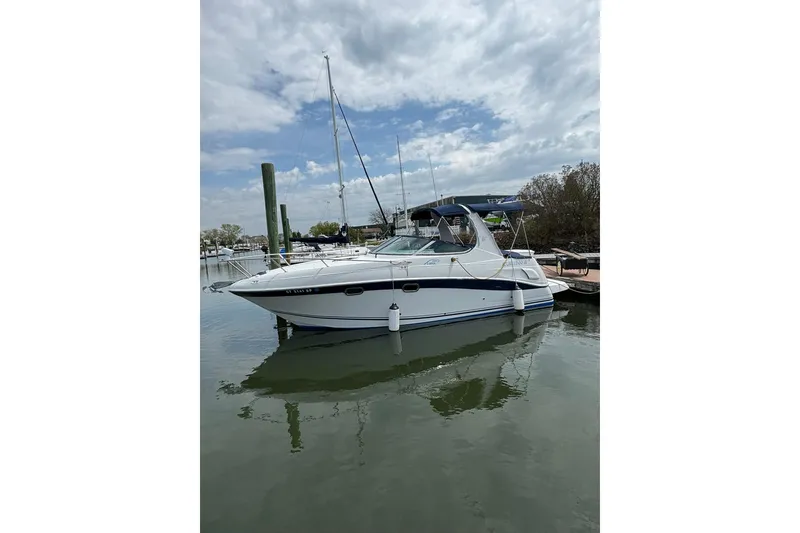 Slide: The Image of 2004 Four Winns 268 Vista boat docked in a marina under cloudy skies. - 40
