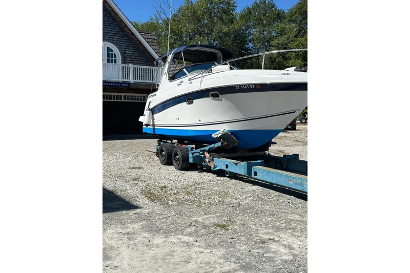 Slide: The Image of 2004 Four Winns 268 Vista boat on trailer, parked outside a building. - 44