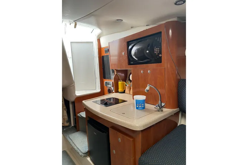 Slide: The Image of 2004 Four Winns 268 Vista boat interior with kitchenette, microwave, and compact fridge. - 48