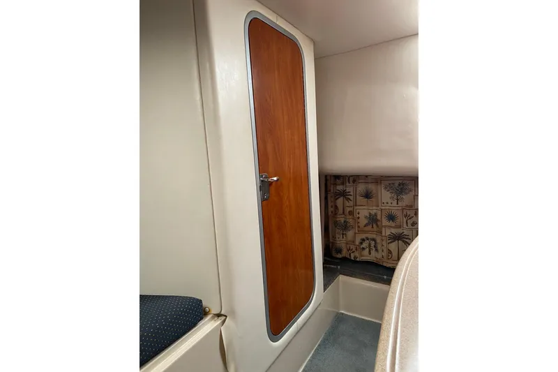 Slide: The Image of Interior cabin of 2004 Four Winns 268 Vista boat with wooden door and patterned curtain. - 49