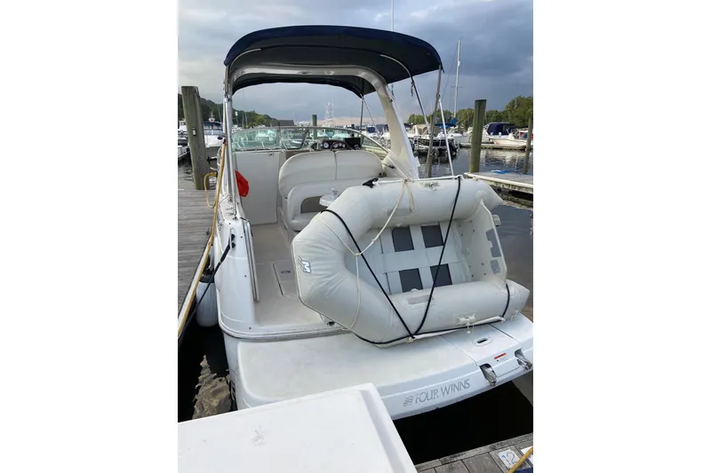 Slide: The Image of 2004 Four Winns 268 Vista boat with inflatable dinghy at marina dock. - 57