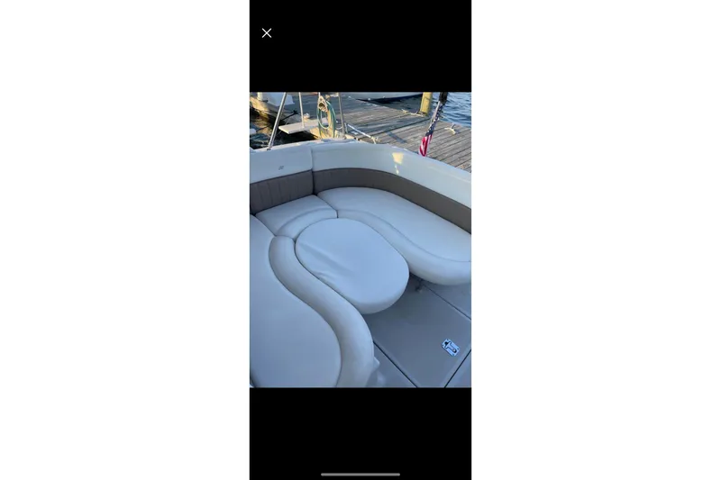 Slide: The Image of 2004 Four Winns 268 Vista boat with plush seating and dock view. - 58
