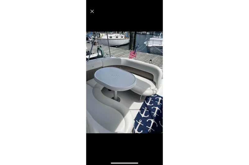 Slide: The Image of 2004 Four Winns 268 Vista boat interior with seating and table, docked at marina. - 61