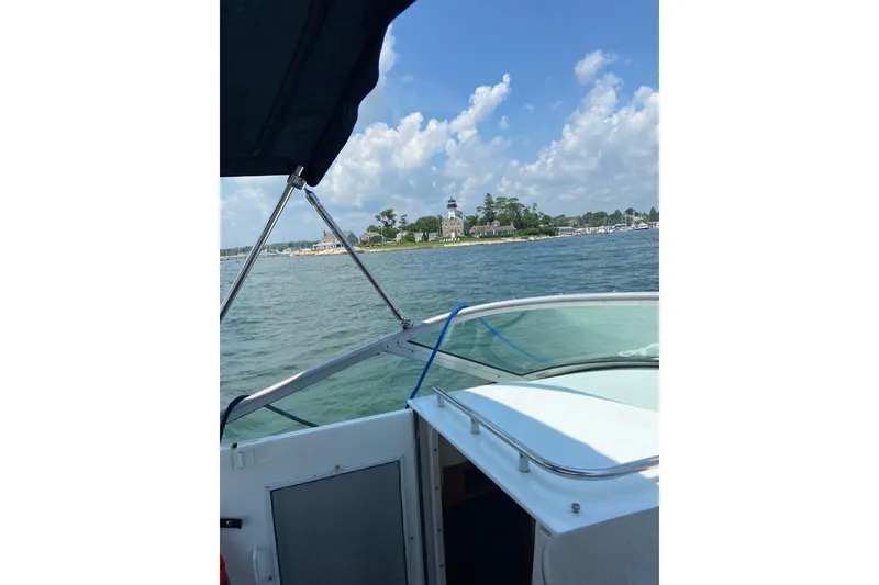 Slide: The Image of 2004 Four Winns 268 Vista boat cruising near a scenic shoreline with lighthouse. - 71