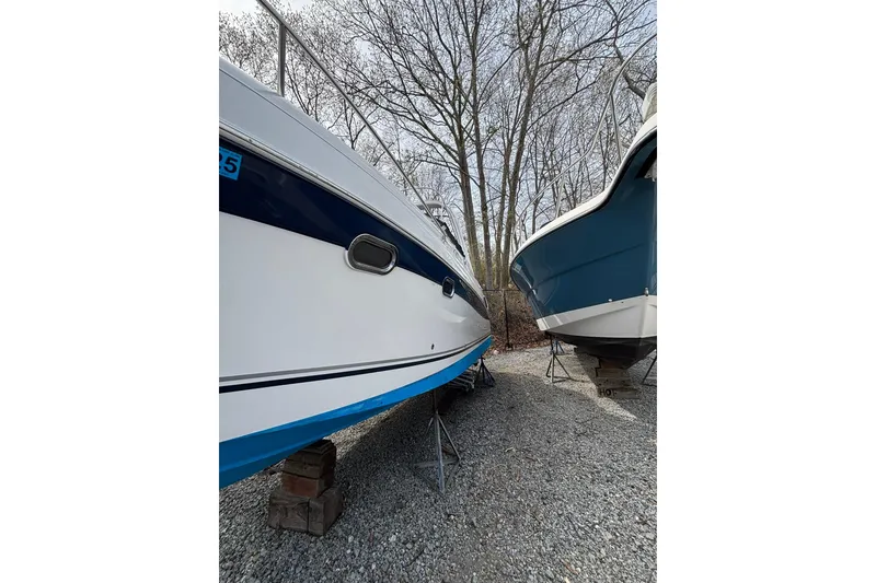 Slide: The Image of 2004 Four Winns 268 Vista boat on stands, surrounded by trees. - 74