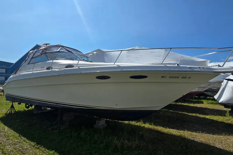 Slide: The Image of 1998 Sea Ray 330 Sundancer boat on land under clear blue sky. - 1