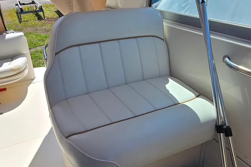 Slide: The Image of White leather seat on 1998 Sea Ray 330 Sundancer boat, featuring sleek design and chrome accents. - 10