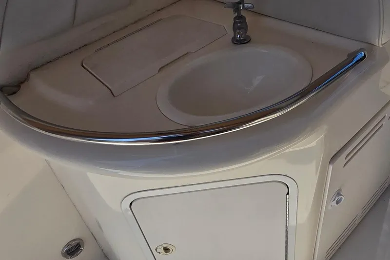 Slide: The Image of 1998 Sea Ray 330 Sundancer boat sink with chrome faucet and storage compartment. - 12