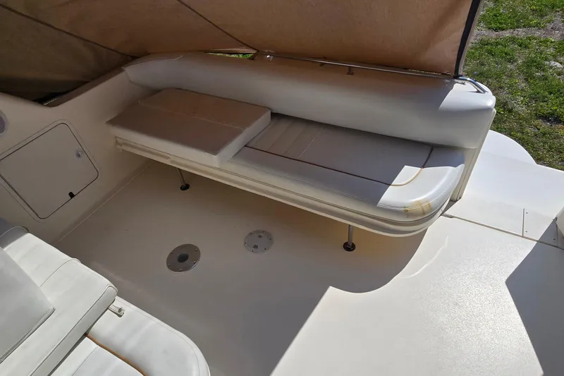 Slide: The Image of 1998 Sea Ray 330 Sundancer boat interior with cushioned seating and storage compartment. - 13