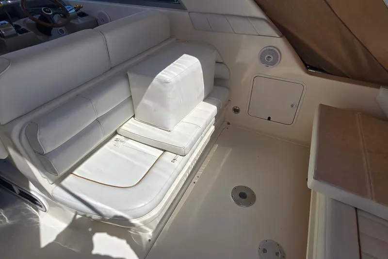 Slide: The Image of 1998 Sea Ray 330 Sundancer interior with white seating and steering wheel. - 14