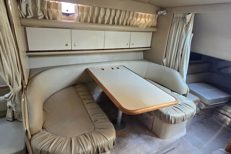 Slide: The Image of 1998 Sea Ray 330 Sundancer interior with beige seating and dining table. - 20