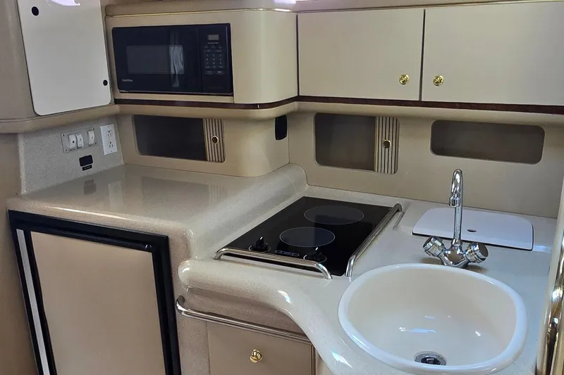 Slide: The Image of 1998 Sea Ray 330 Sundancer galley with stove, sink, and microwave. - 21