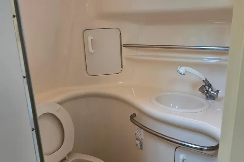Slide: The Image of 1998 Sea Ray 330 Sundancer bathroom with toilet, sink, and storage compartment. - 26
