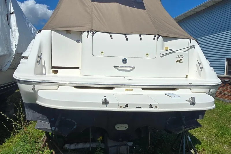 Slide: The Image of 1998 Sea Ray 330 Sundancer boat, rear view with canopy, parked outdoors. - 4