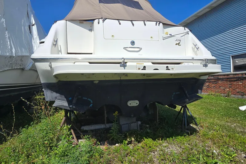 Slide: The Image of 1998 Sea Ray 330 Sundancer boat on land, rear view, with blue sky background. - 6